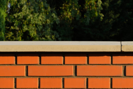 View of the brick base. Brick wall with white finished top with polished white capstone. Brick base....