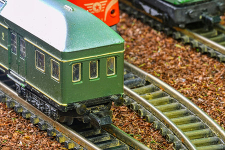 Close-up of a detailed miniature green train carriage on a model railway track. A detailed close-up...