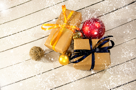 New year and Christmas gift boxes in rustic style on a wooden white background. Snow and the sparkle of xmas winter snowflakes. Eve decorations. Joyeux Noelの写真素材