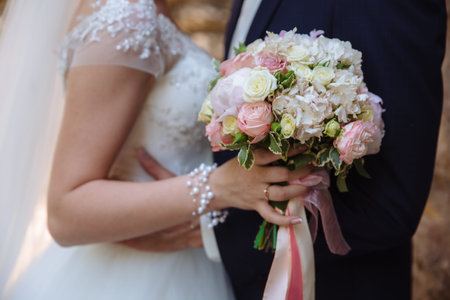 Wedding bouquet in marriage couple hands.