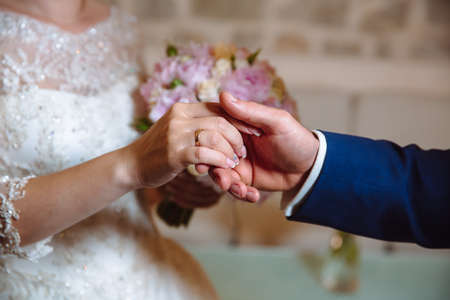 Bride and groom's hands with wedding gold ringsの写真素材