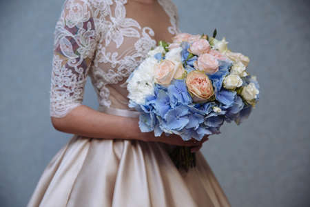 Beautiful wedding bouquet in hands of brideの写真素材