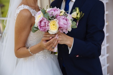 Wedding bouquet in marriage couple hands.の写真素材
