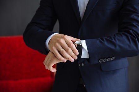 Businessman checking time on his wristwatch. men's hand with a watchの写真素材