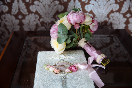 Wedding gold rings and bouquet of flowers on a dark wooden table. Concept of marriage.の写真素材