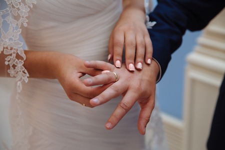 Bride and groom's hands with wedding gold ringsの写真素材