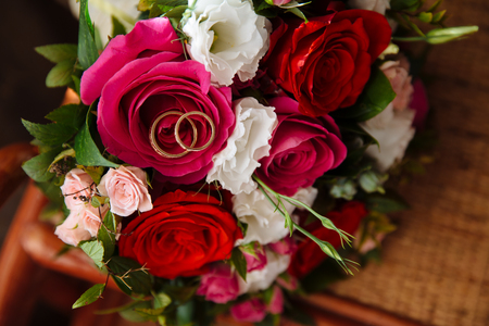 gold wedding rings lie on a bouquet of flowers.の写真素材