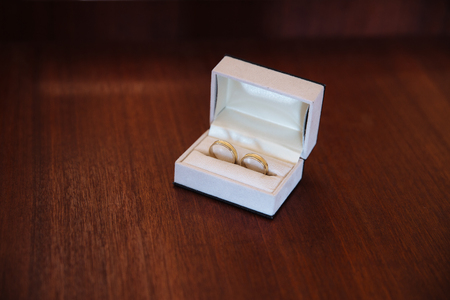 Gold ring in white box lie on brown background.の写真素材