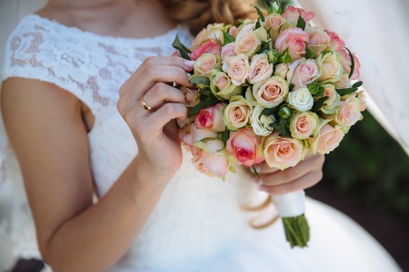 Beautiful wedding bouquet in hands of brideの写真素材