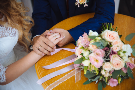 Bride and groom's hands with wedding gold ringsの写真素材