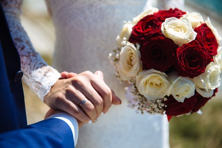 Bride and groom's hands with wedding gold ringsの写真素材