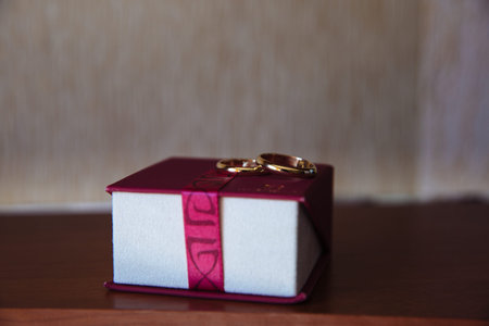 golden wedding rings on a dark background in red box