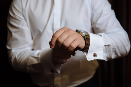 Businessman checking time on his wristwatch. men's hand with a watch