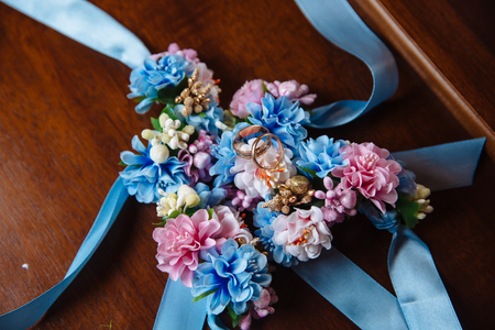 Gold rings on wedding bouquet of blue and white fresh flowersの写真素材
