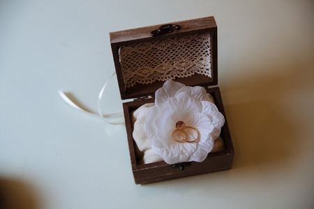 Wedding gold rings in a wooden box on the white backgroundの写真素材