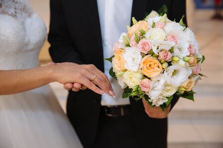 Bride and groom's hands with wedding gold ringsの写真素材