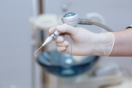 Dentist doctor hand holding medical tools in dental office. Concept healthyの写真素材