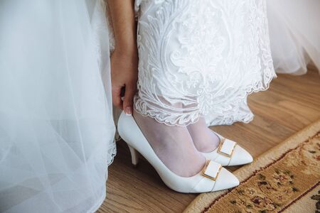 the bride wears white shoes on foot in the wedding dayの写真素材