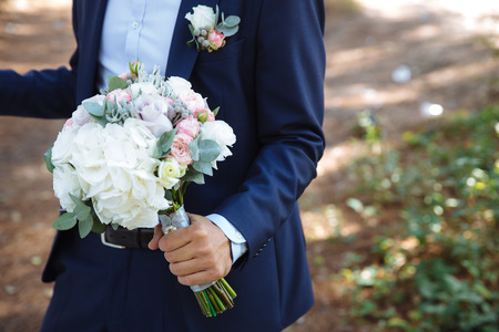 Wedding bouquet in groom hands, close upの写真素材