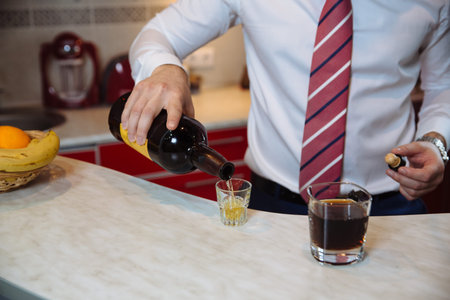 Businessman pouring whiskey in his glassの写真素材