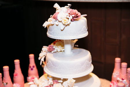 Part of wedding cake decorated with pink bottles of champagne. Candy barの写真素材