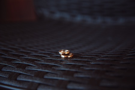 Two wedding rings laying on the white tableの写真素材