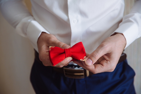 Man holding red bow tie. Elegant gentleman clother.の写真素材