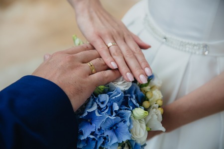 Closeup groom and bride are holding hands at wedding day ang show rings. Concept of love familyの写真素材