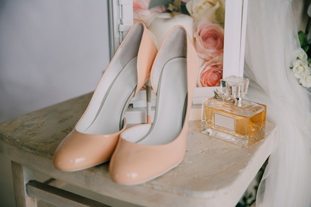 Bridal accessories on a white chair with flowers, perfume shoes. Clothing conceptの写真素材