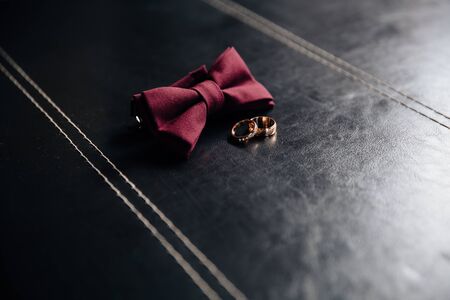 Wedding groom accessories, details of clothes, bow tie, golden rings.の写真素材