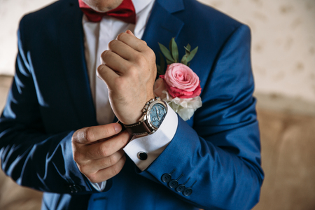 Man in blue jacket with boutonniere wear wrist watches. Concept of jewelry, dressの写真素材
