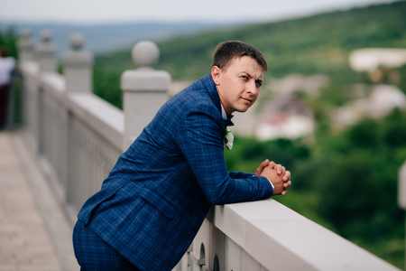 The business man leaned his elbows on the parapet, thinking hard about his affairs. The guy pensively lops his forehead alone.の写真素材