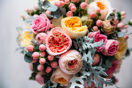 Top view of a close-up of a bright bridal bridal bouquet, on a flower lay engagement gold rings.の写真素材