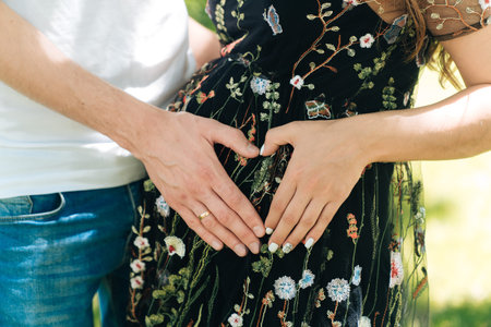 Close-up of loving hands in the shape of a heart. Husband and wife connect their hands against the...