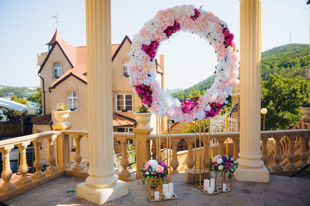 The concept of wedding decor, street decoration, wedding arch is decorated with flowers - pink and white peonies. Wedding day, ceremony place for the bride and groom, decor, flowers, florists.の写真素材