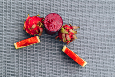 Close up glass of dragon fruit smoothie and fruits on textured table backgroundの写真素材