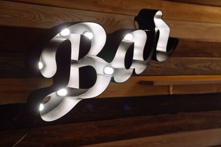 Lighted title signboard Bar, wooden wall on background.の写真素材