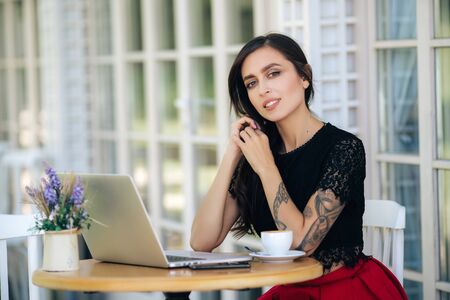 Beautiful girl businesswoman working on laptop in cafe, female freelancerの写真素材