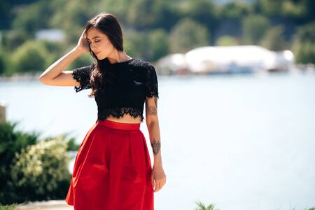 Stylish attractive girl with beautiful smile posing near lake on summer dayの写真素材