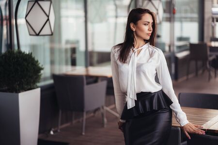 Business woman poses in cafe, beautiful girl rests during her breakの写真素材
