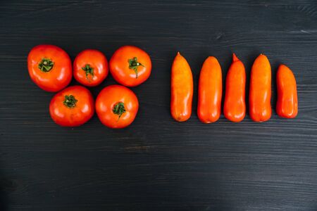 Top view of red cherry tomatoes on black wooden background with copy spaceの写真素材