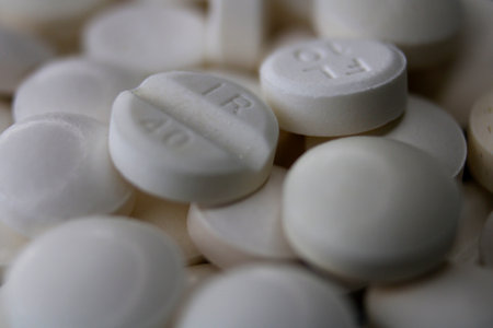 Close-up of a pile of round white tablets on a black background.の写真素材