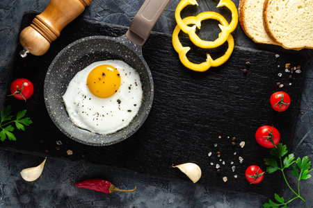 Fried eggs in a frying pan with fresh vegetables and spices. Concept for menu and advertising.の写真素材
