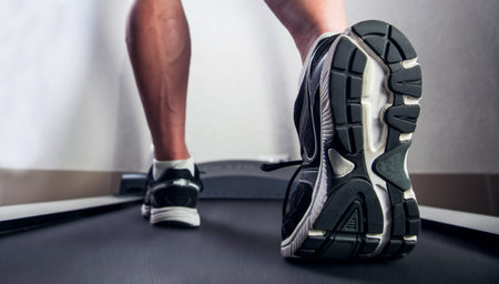 fit male legs on a treadmill at the gym