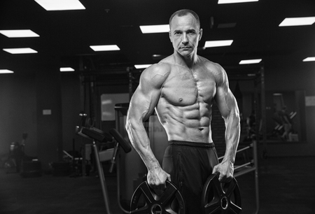 Brutal strong athletic men pumping up muscles workout bodybuilding concept backgroundの写真素材