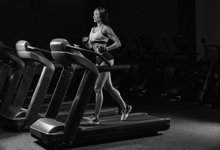Pretty girl working out in a treadmill at the gymの写真素材