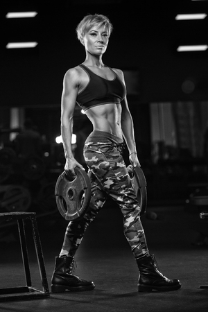 fitness girl exercising with barbell in gymの写真素材