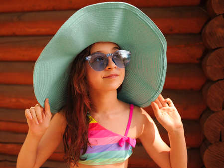 Portrait of a beautiful girl with glasses. Girl in a hat and glasses in the summer.の写真素材