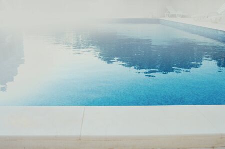 blue clean water in swimming pool in the foggy summer morning, with space for textの写真素材