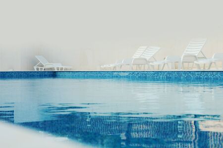 turquoise, blue clean water in swimming pool in the foggy summer morning, with space for textの写真素材